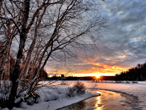 sunrising over a snowy river bank