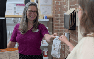 Pharmacist hands a bag to a patient
